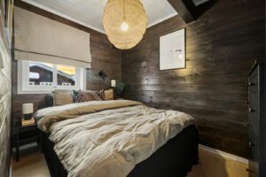 A bedroom with a large bed and wooden walls